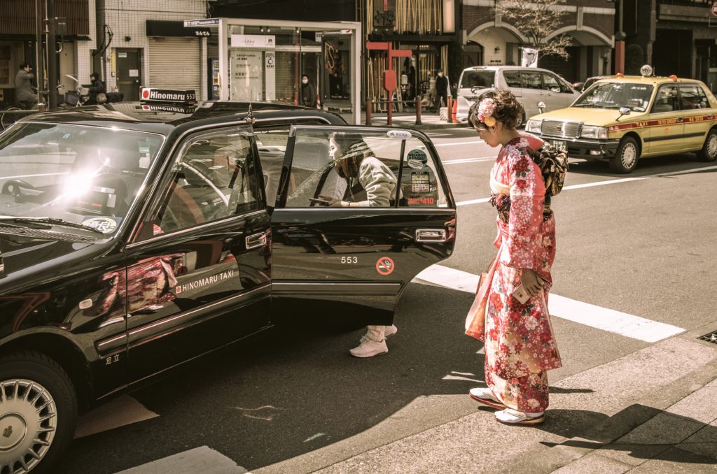 Touristen-Geisha steigt ins Taxi in Tokio